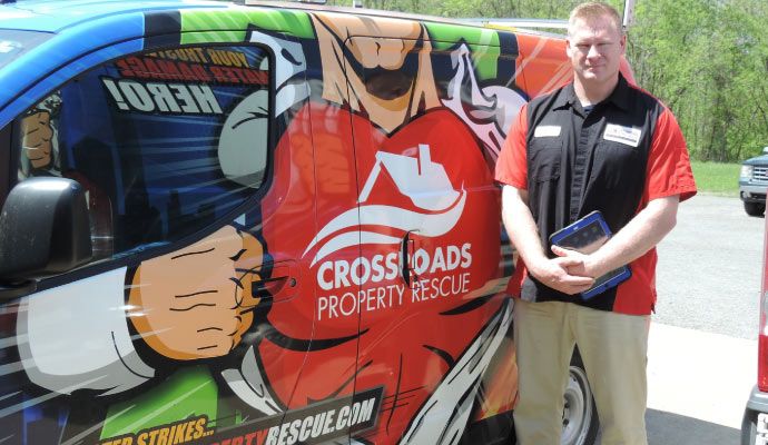 Professional worker standing next to Crossroad service van