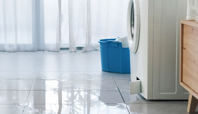 Washing machine leaking water on tile floor