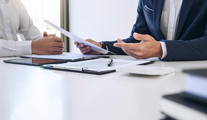 A client receiving guidance from an assistant while reviewing an insurance document