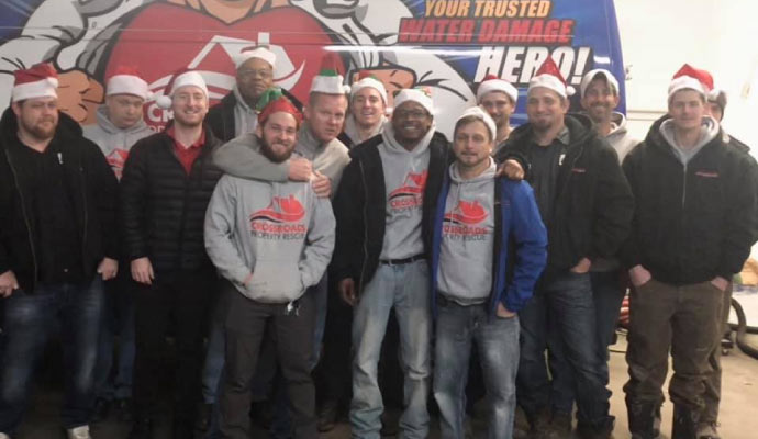 Crossroads Property Rescue team standing in front of their service vehicle