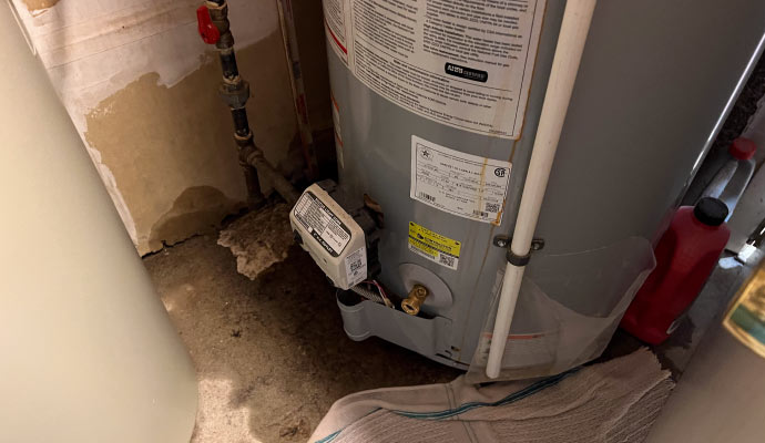 Close-up view of water heater leaking